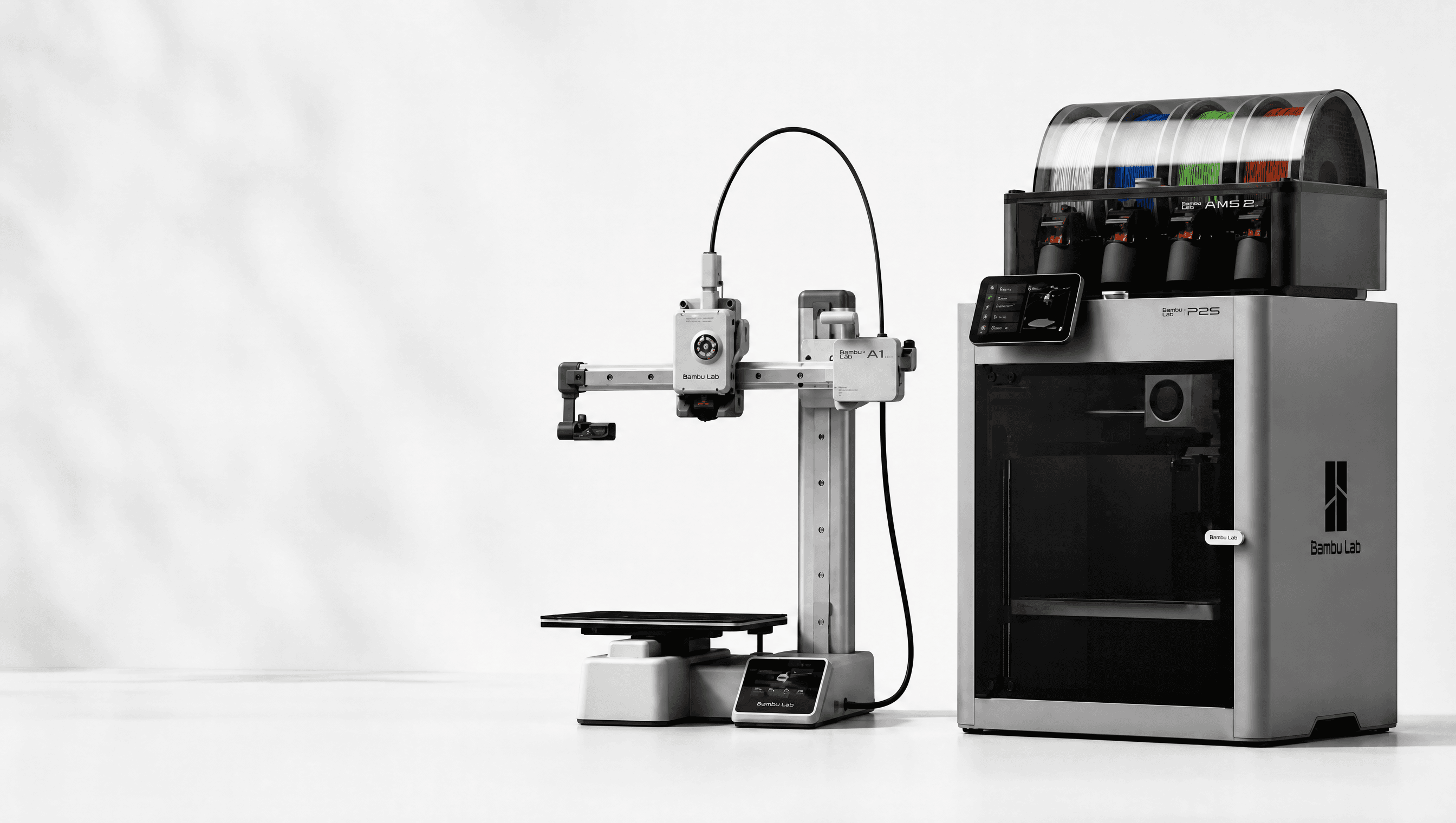 A Bambu Lab A1 and P2S 3D printer side by side on a clean studio background