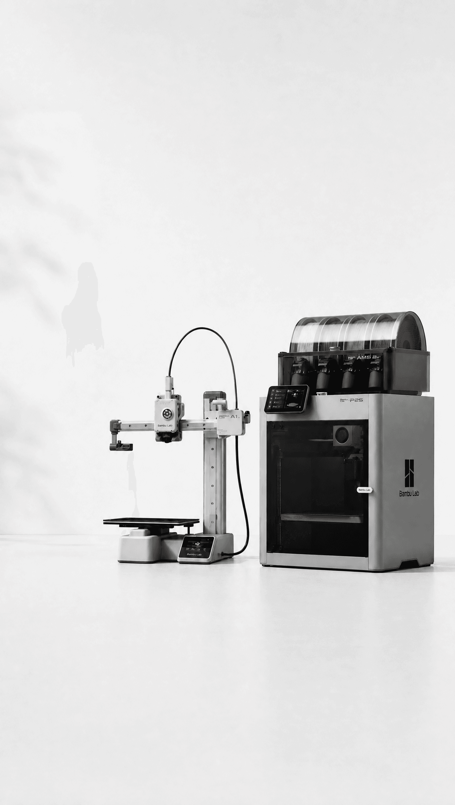 A Bambu Lab A1 and P2S 3D printer side by side on a clean studio background